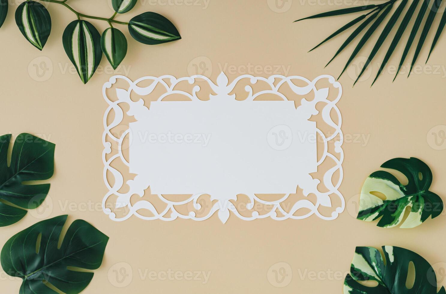 Trendy summer composition made with green tropical leaves and paper card note on sand color background. Minimal concept. Exotic flat lay. Creative copy space. photo