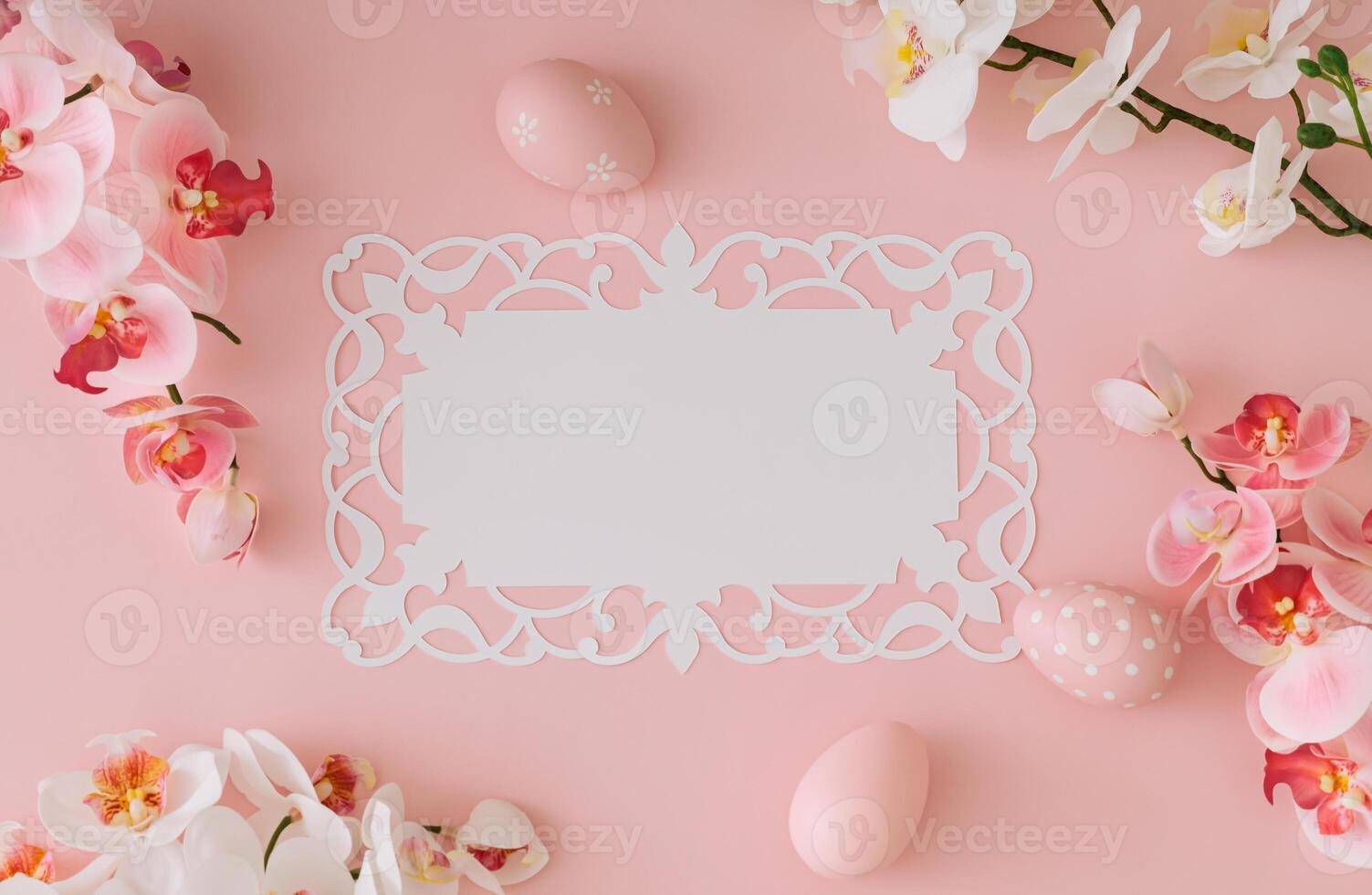 Spring composition made with pink colored Easter eggs and orchid flowers with paper card copy space on light pastel pink background. Minimal Easter concept. Creative festive holiday layout. Flat lay. photo