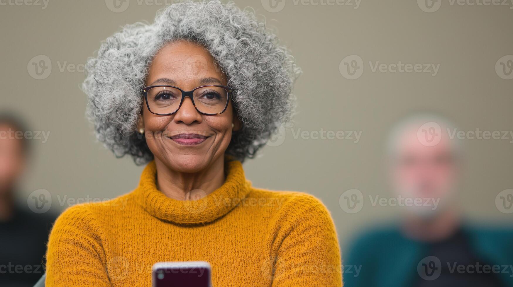 Seniors Engaged in Technology Workshop Learning Smartphone Use, Featuring a Smiling Woman in a Cozy Orange Sweater photo
