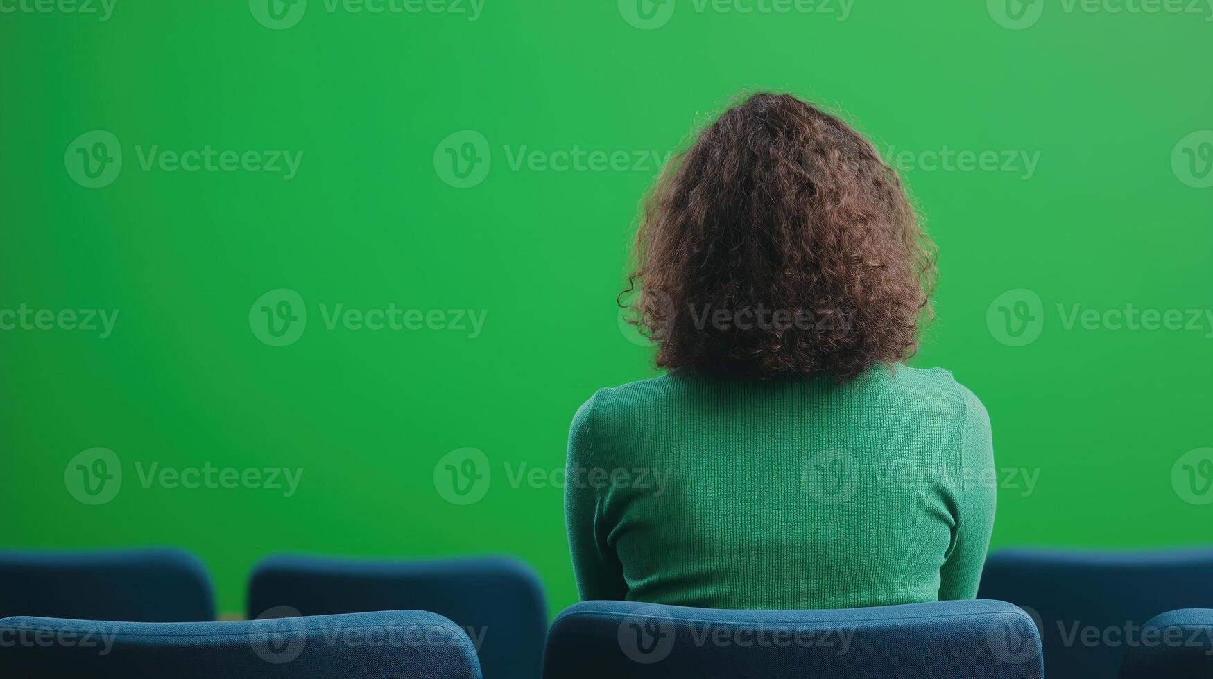 Audience at Conference in Theater Room Cinema Movie Viewing from Behind with Empty Chair and Green Screen Background Space photo