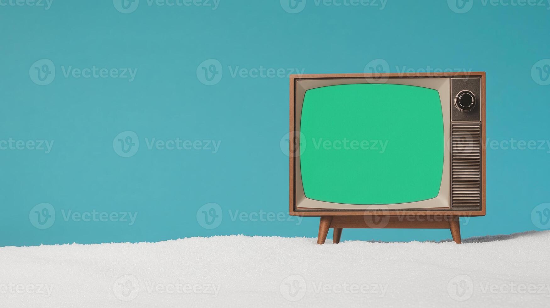 Vintage Television with Glowing Green Screen on Snowy Surface Against Blue Sky Background for Retro Concepts and Creative Designs photo