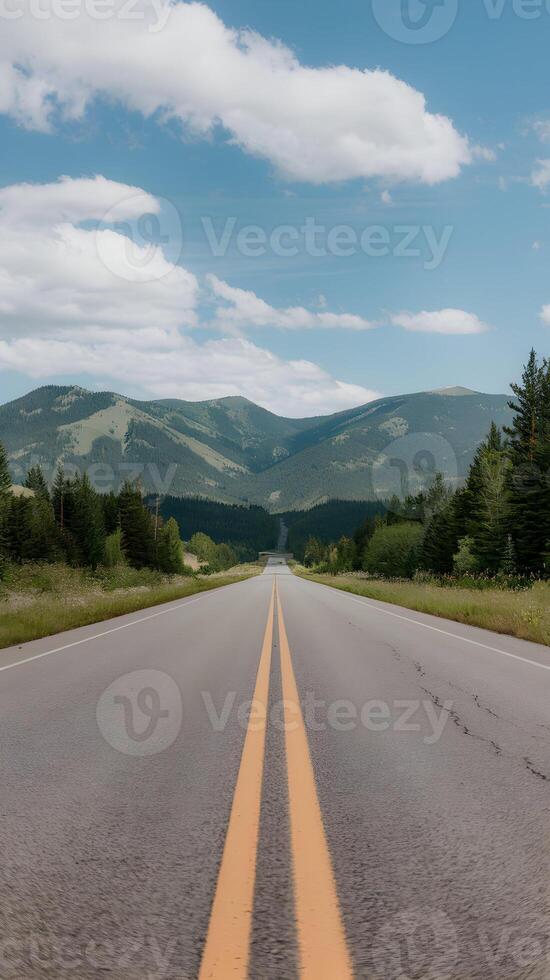 Scenic road lined with green mountains, leading towards clear blue sky and clouds. Vertical Mobile Wallpaper photo