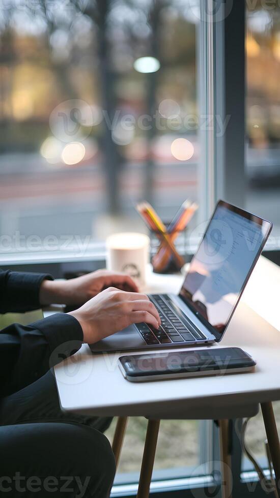 Typing hands at laptop, ambient light and window view suggest productivity Vertical Mobile Wallpaper photo
