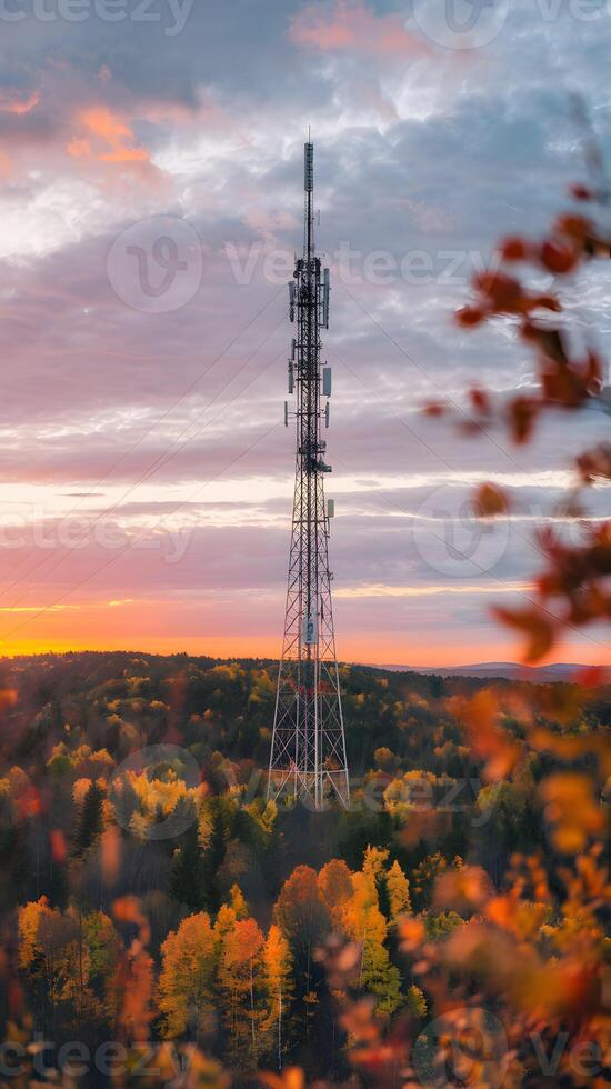 Communication tower above autumn forest blends technology with seasonal natural beauty Vertical Mobile Wallpaper photo