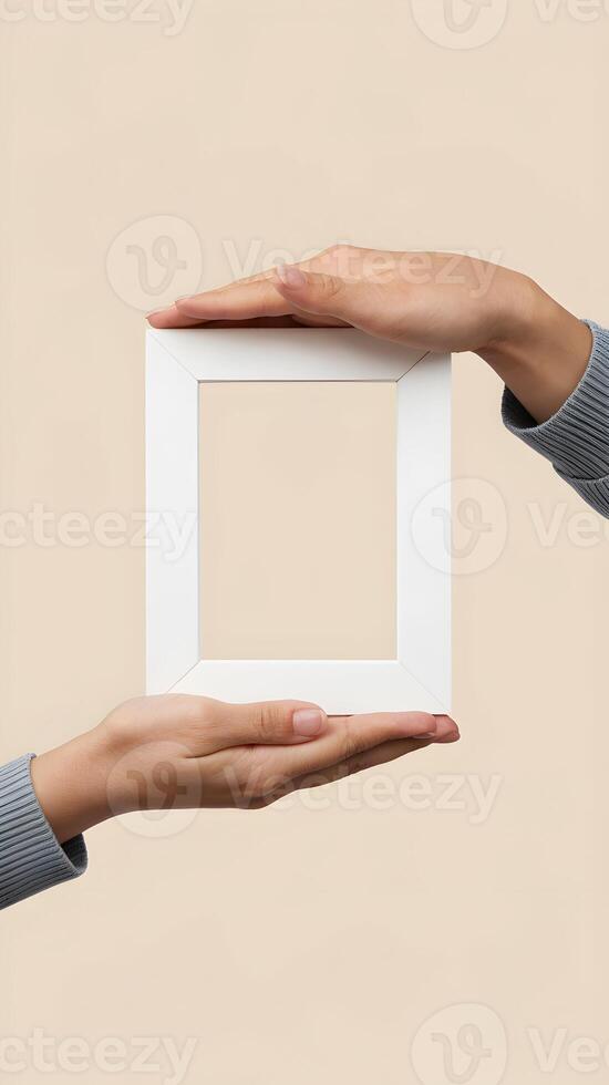 Hands present an empty white frame, emphasizing simplicity and creative possibilities Vertical Mobile Wallpaper photo