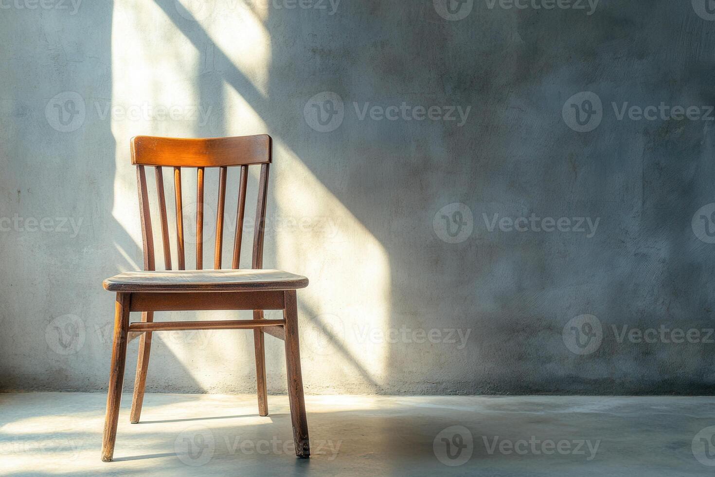 Wooden Chair Against A Textured Wall In Sunlight photo