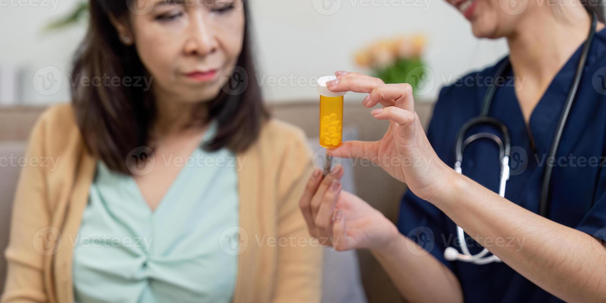 Caregiver showing medication bottle to elderly patient for better understanding photo
