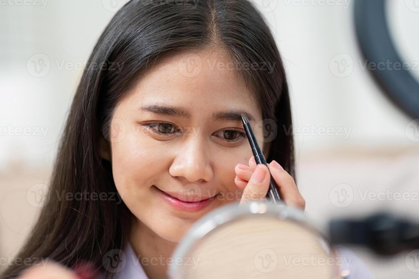 Beauty broker applying eyebrow makeup during a live broadcast tutorial photo