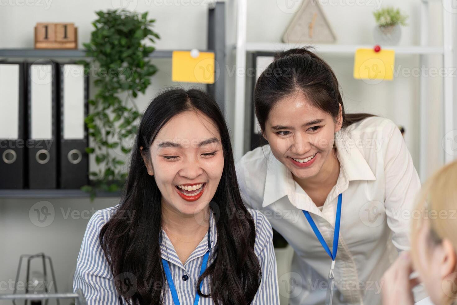 Two business professionals sharing a joyful moment while collaborating in an office photo
