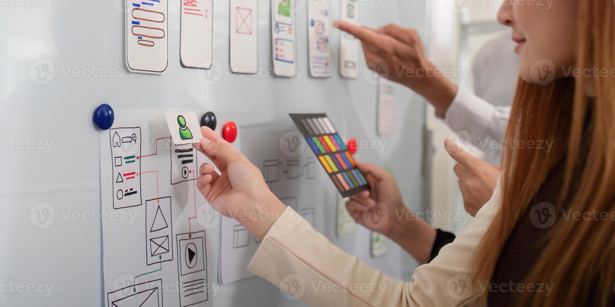 Collaborative UX UI team refining app designs on a whiteboard, illustrating dynamic creativity and teamwork photo