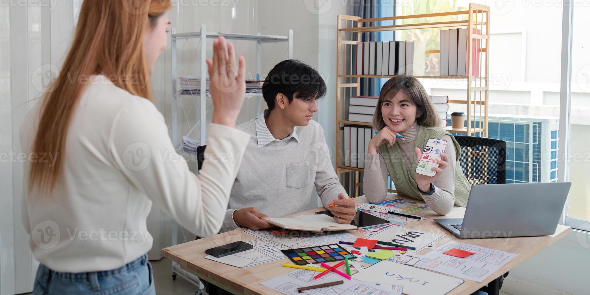 Creative UX UI team collaborating on design project in a modern office, showcasing diverse professionals photo