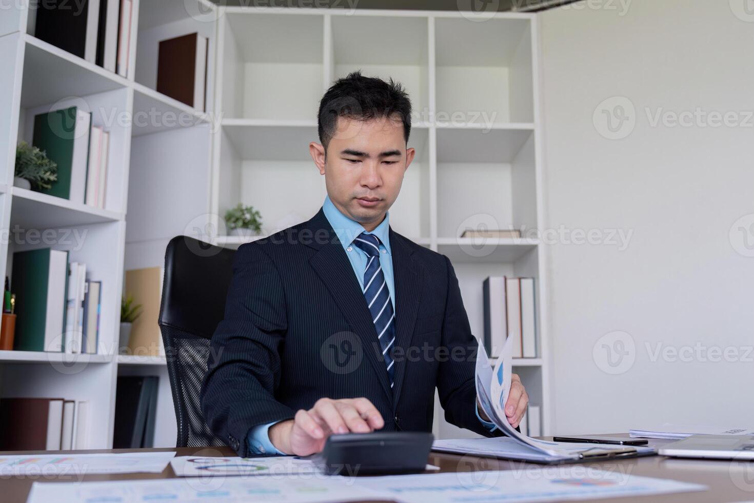 Professional accountant analyzing financial reports and calculating numbers in a modern office photo