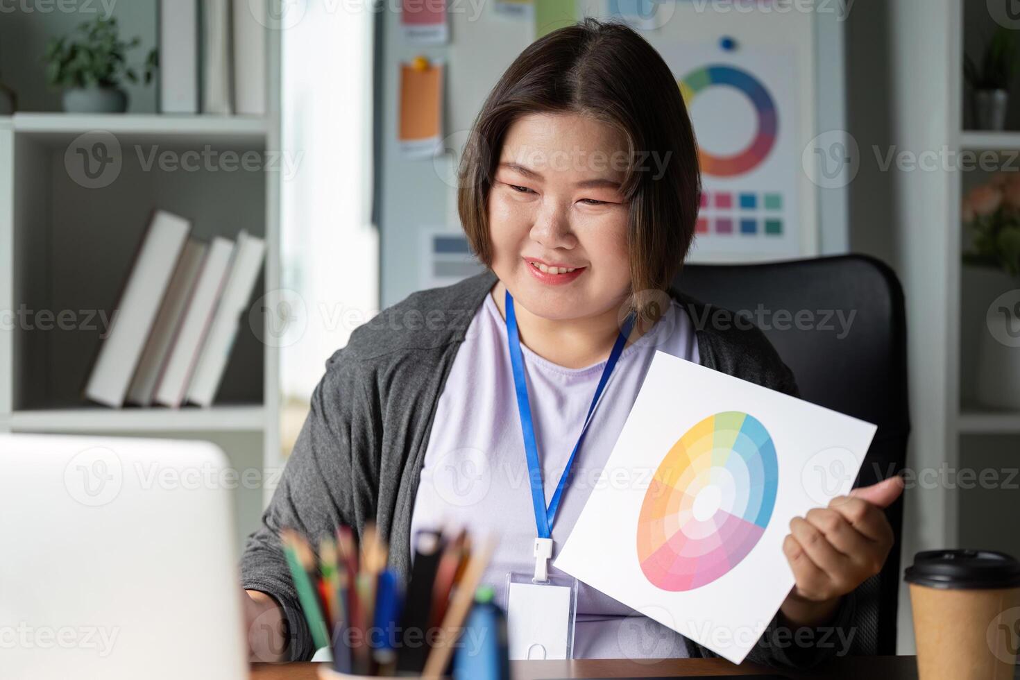 Enthusiastic graphic designer showcasing a color wheel and discussing designs in a modern creative workspace photo