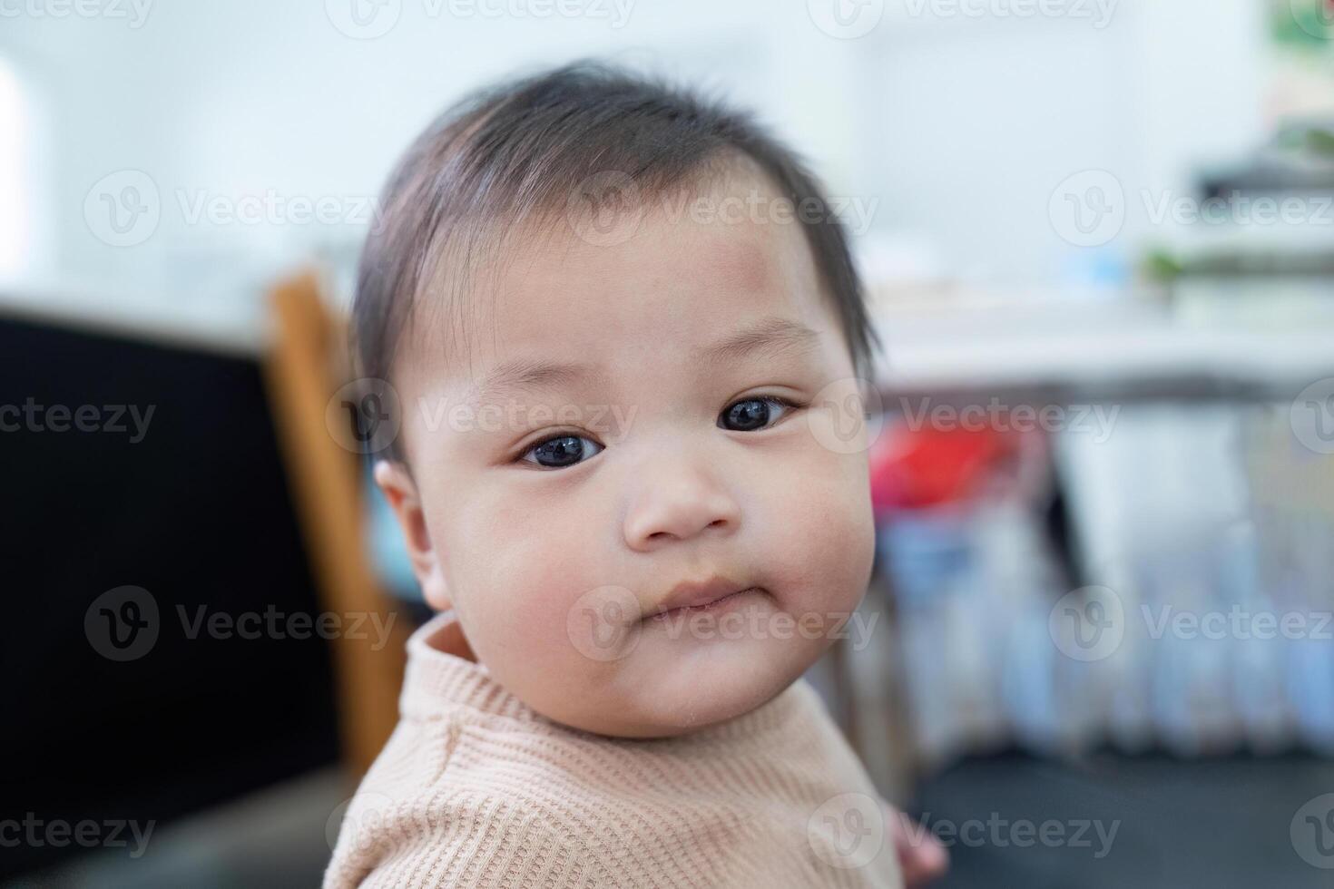 Adorable baby with curious gaze in a cozy indoor setting, showcasing innocence and charm photo