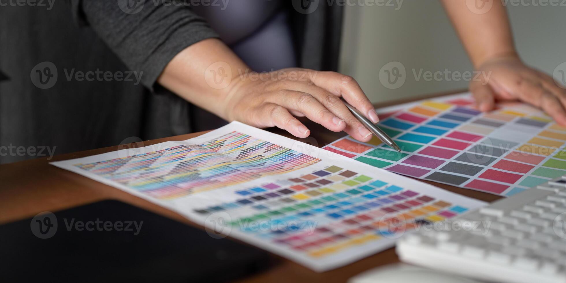 Focused graphic designer selecting color swatches and working on design concepts in a modern office space photo