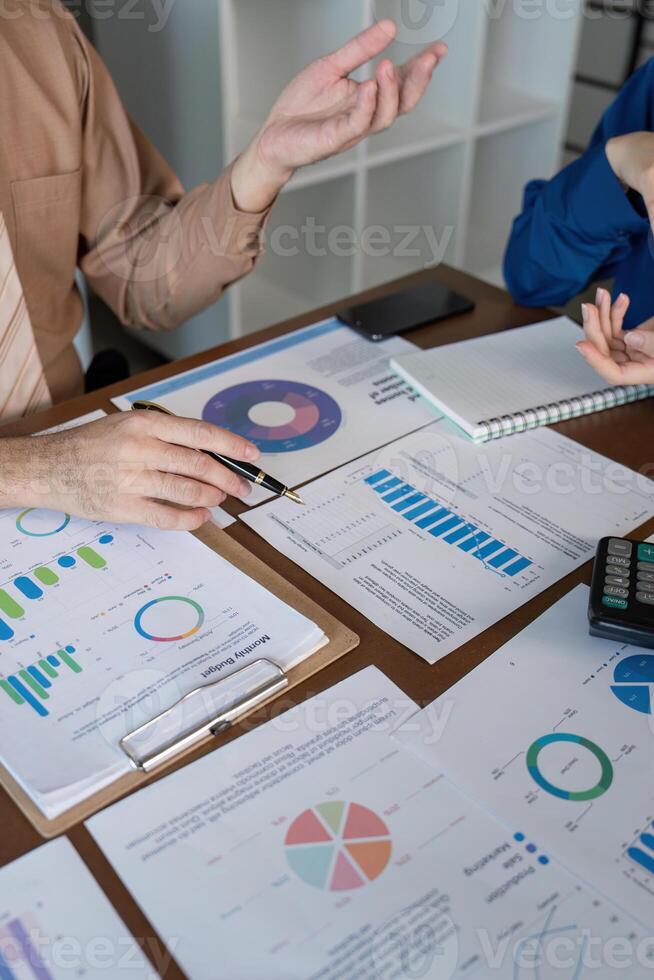 Accountants discussing financial trends and metrics analysis using charts in a professional office photo