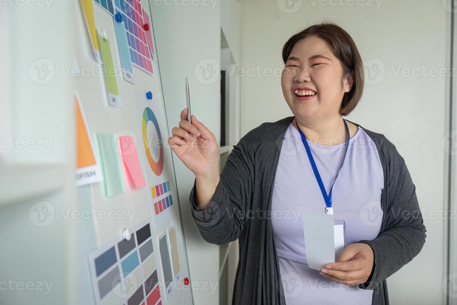 Graphic designer joyfully presenting color selections on a mood board in her creative workspace photo