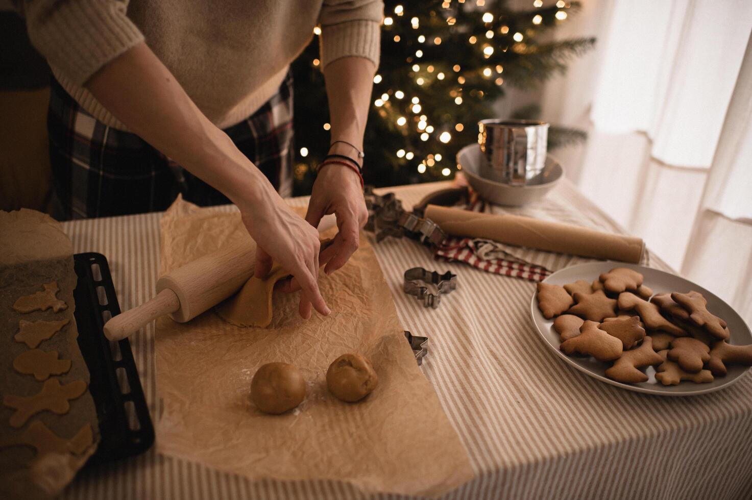 The table is filled with gingerbread dough, and festive cookie cutters are lined up for shaping. photo