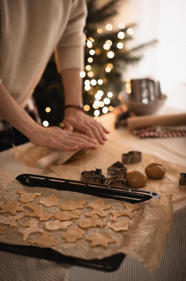 The kitchen counter is filled with gingerbread dough and Christmas-themed cookie cutters for baking. photo