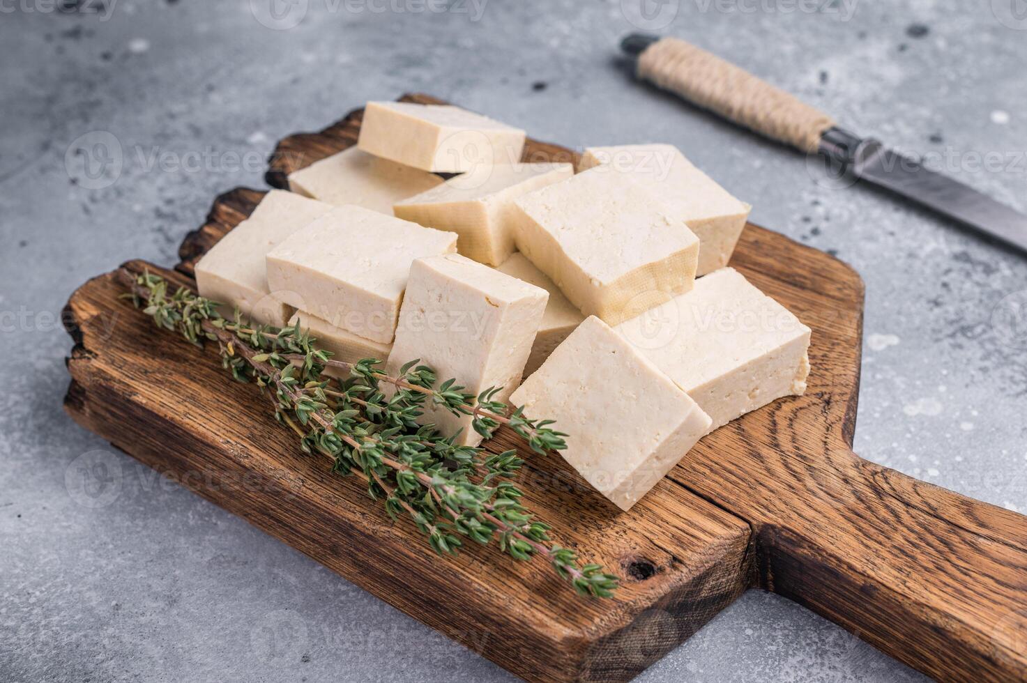 Organic Diced soy tofu cheese on wooden board. grey background. top view photo