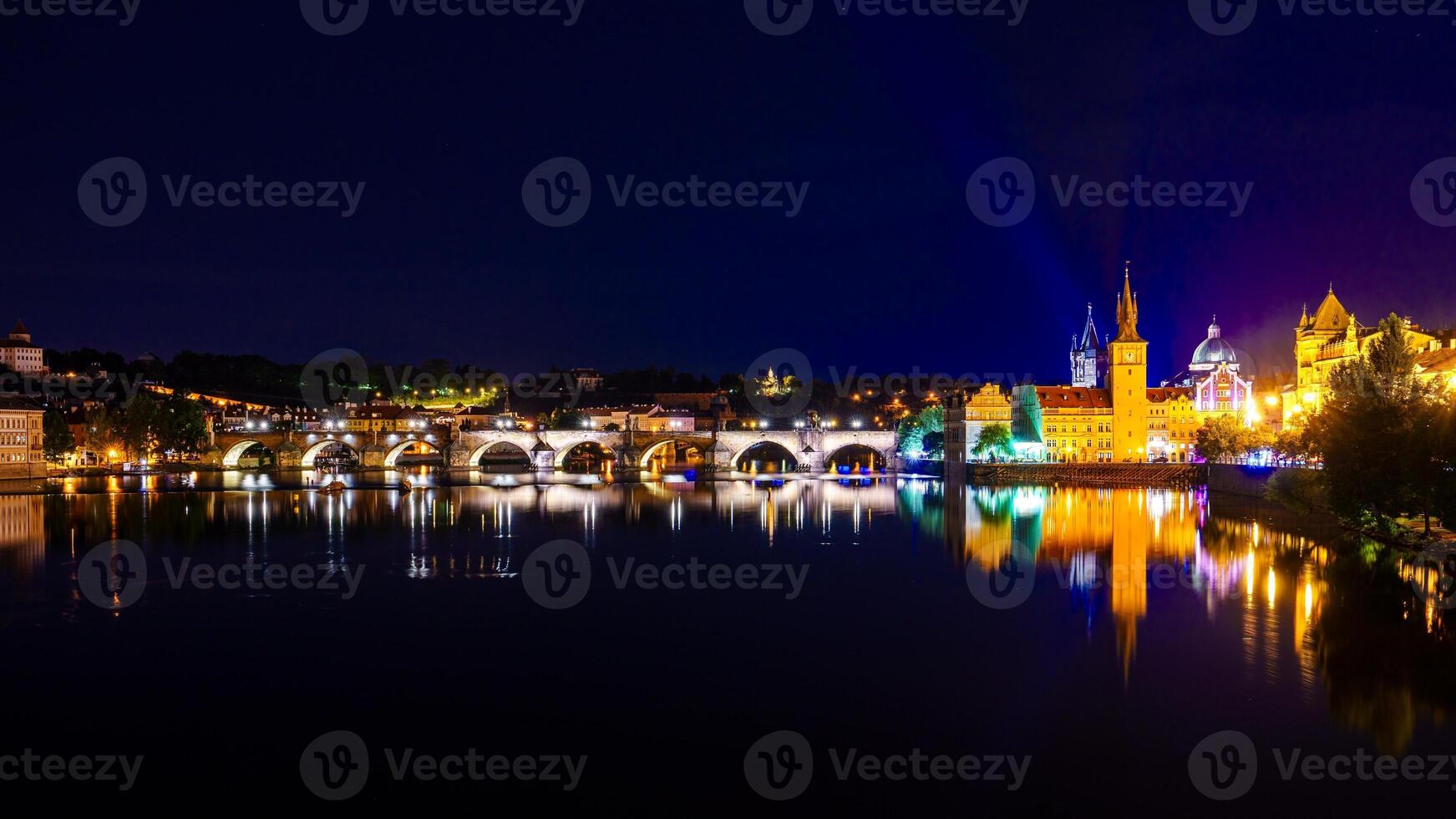 Panoramic view of Prague at night with the Charles Bridge and Prague Castle illuminated photo