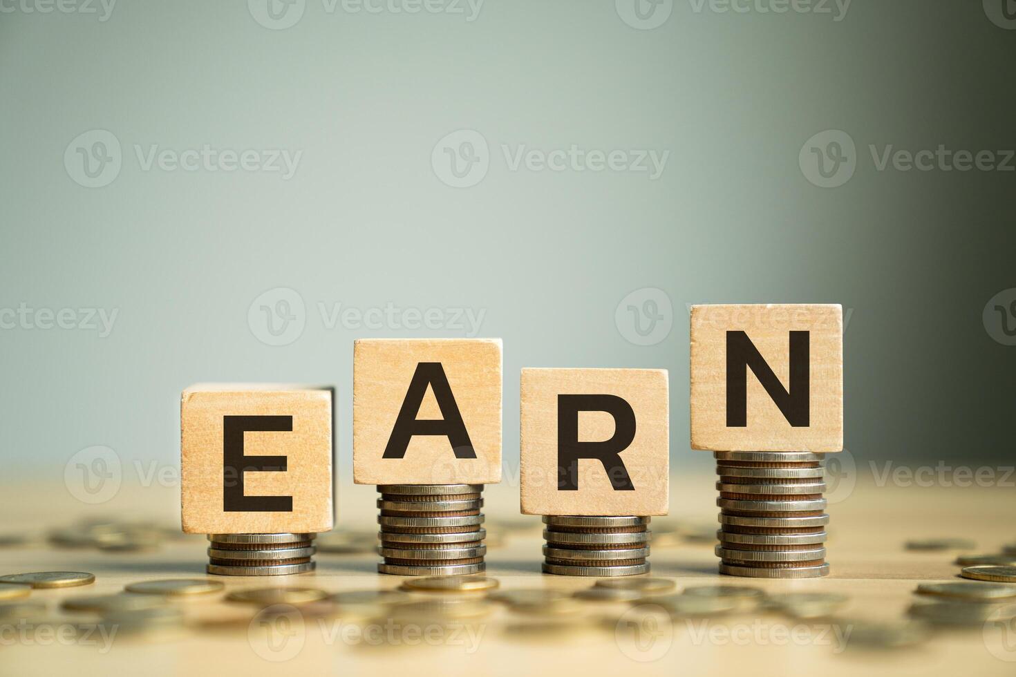 Wooden Block Letters Spelling EARN Placed on Stacked Coins, Representing Income Generation, Earning Money, and Building Wealth for Financial Success and Stability photo