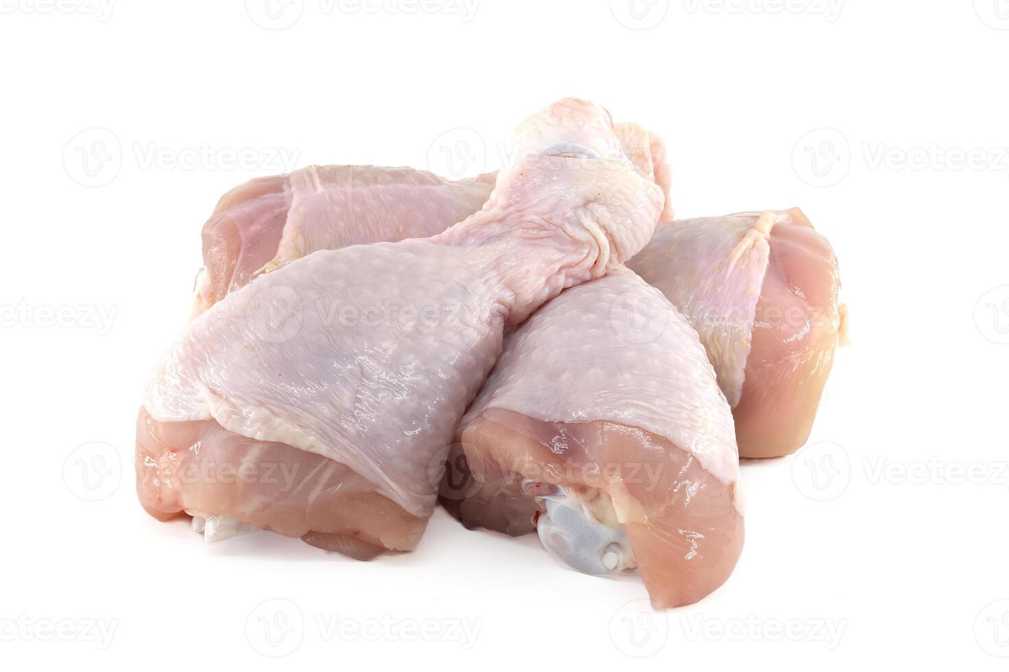 Raw chicken drumsticks resting on a white background photo