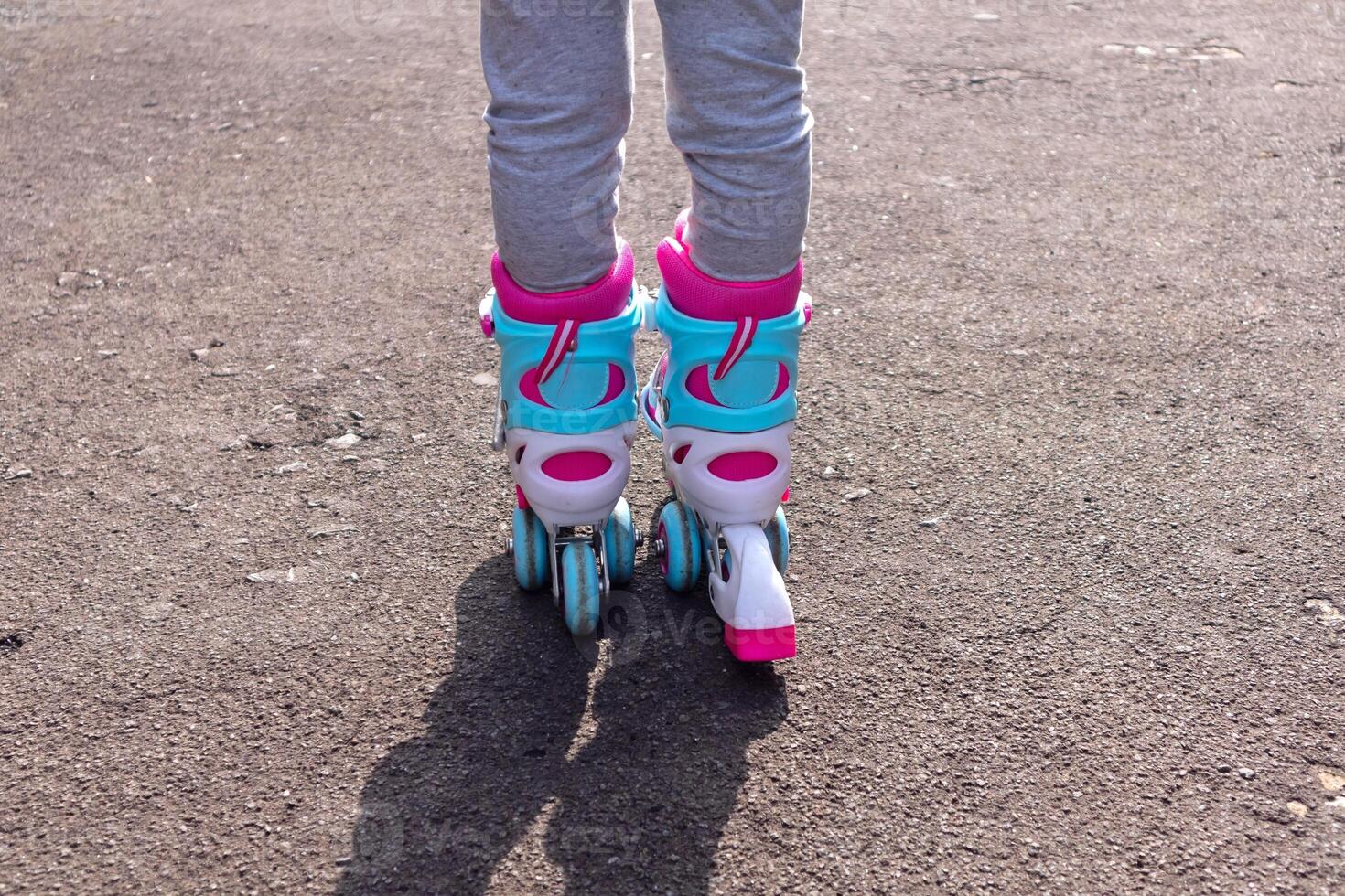 Rear view of a little girl's feet wearing roller skates photo