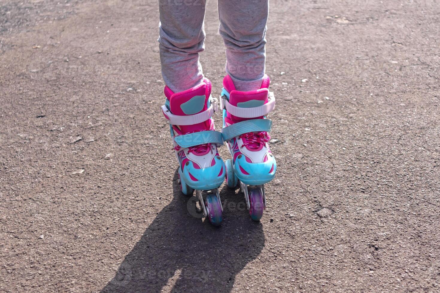 Close up view of a little girl's feet wearing roller skates outdoors photo