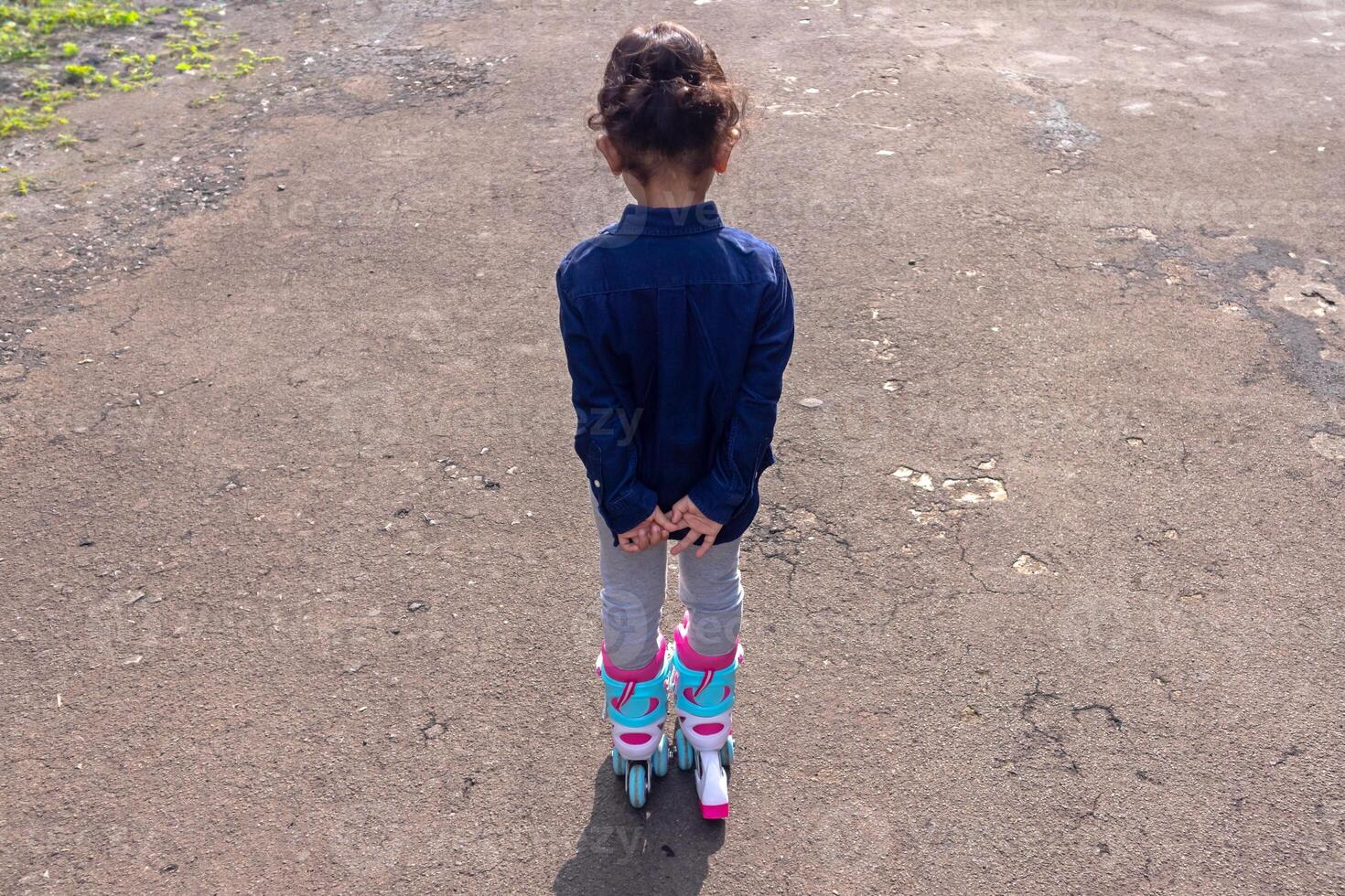 Rear view of a little girl playing roller skates photo