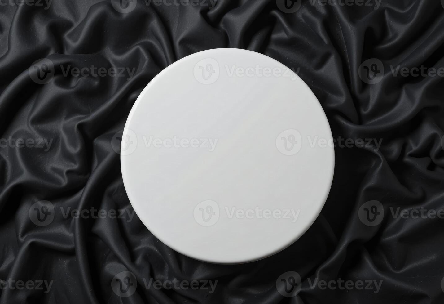 Top view of round white podium stand for cosmetics product presentation on smooth elegant black cloth fabric background photo