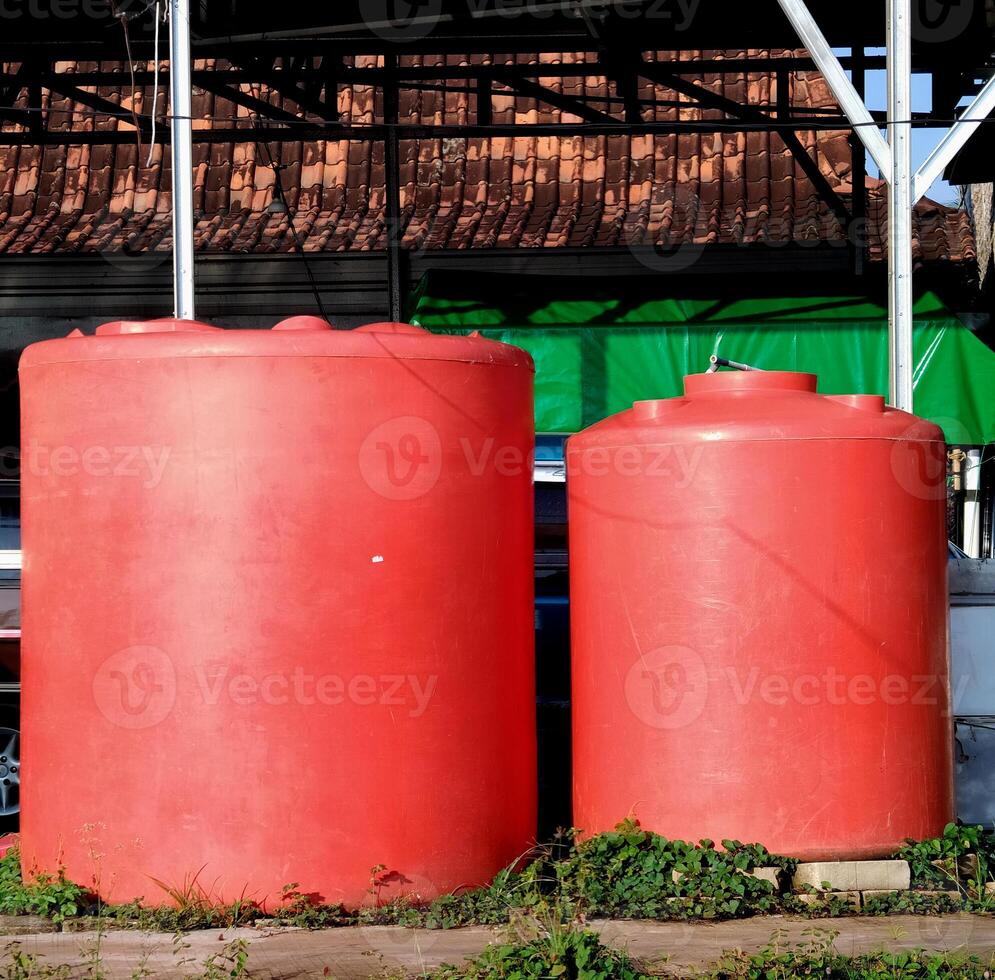 red plastic water tank in outdoor. photo