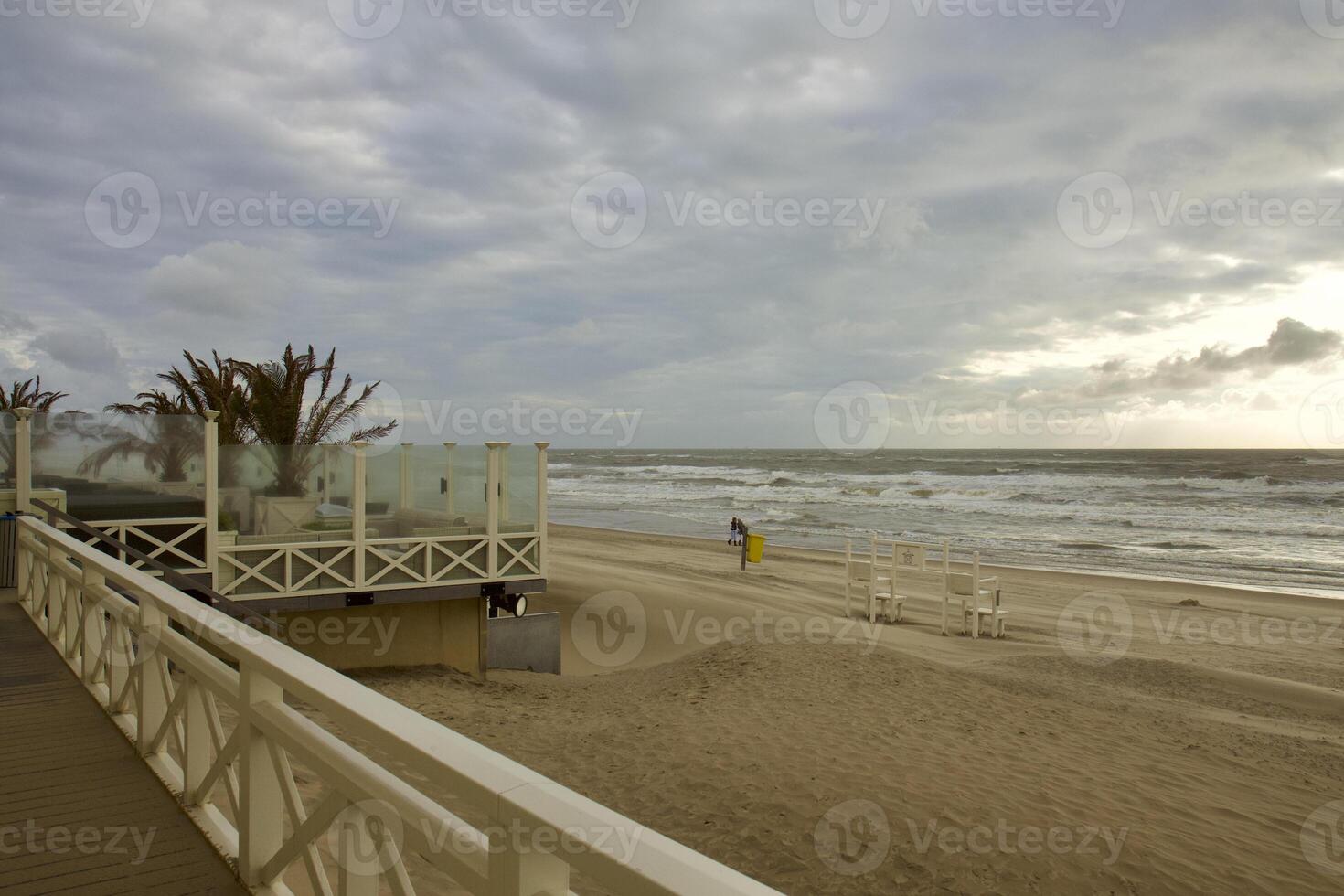 House by the sea. Grey sky, waves and wind photo