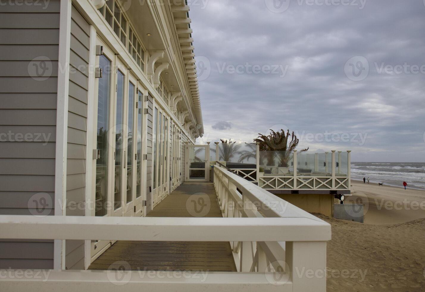 House by the sea. Grey sky, waves and wind photo