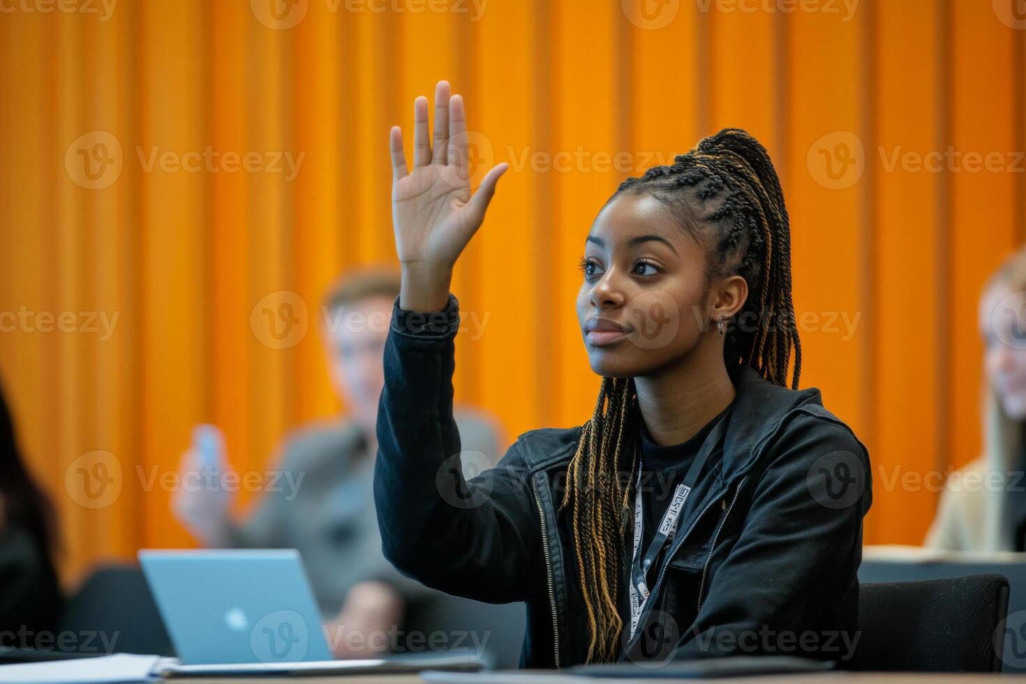Female student raises hand during classroom discussion photo