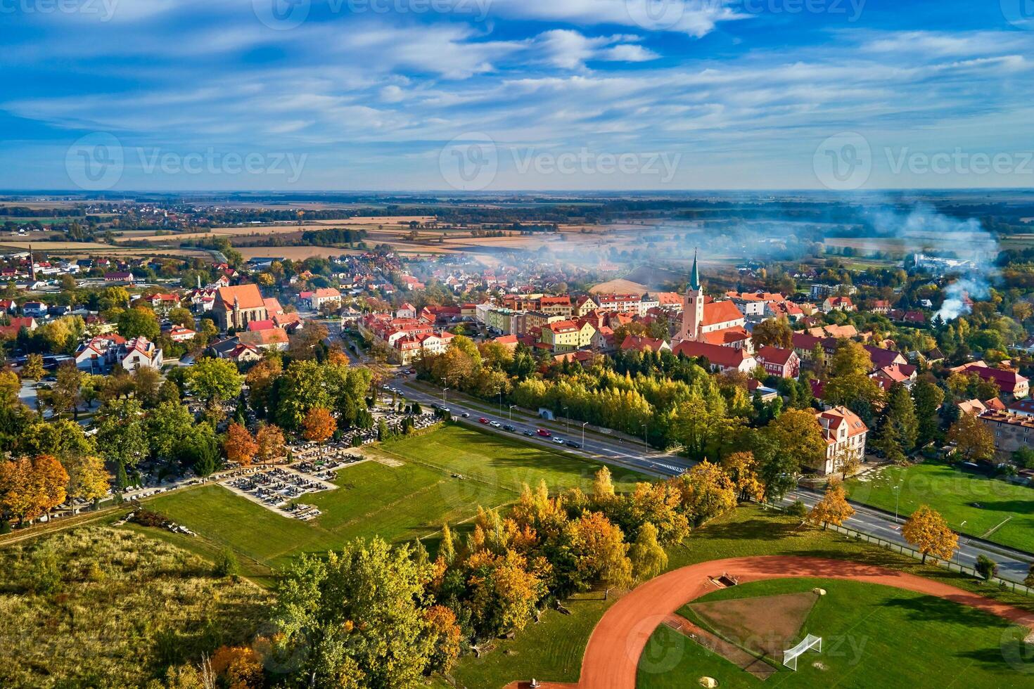 Aerial view of beautiful small town surrounded by fields and forest in autumn season. Bird eye view of village in Poland. Landscape with residential buildings in suburban neighborhood photo