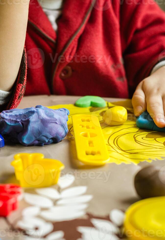 Closeup of plasticine molds and child hands on the background photo