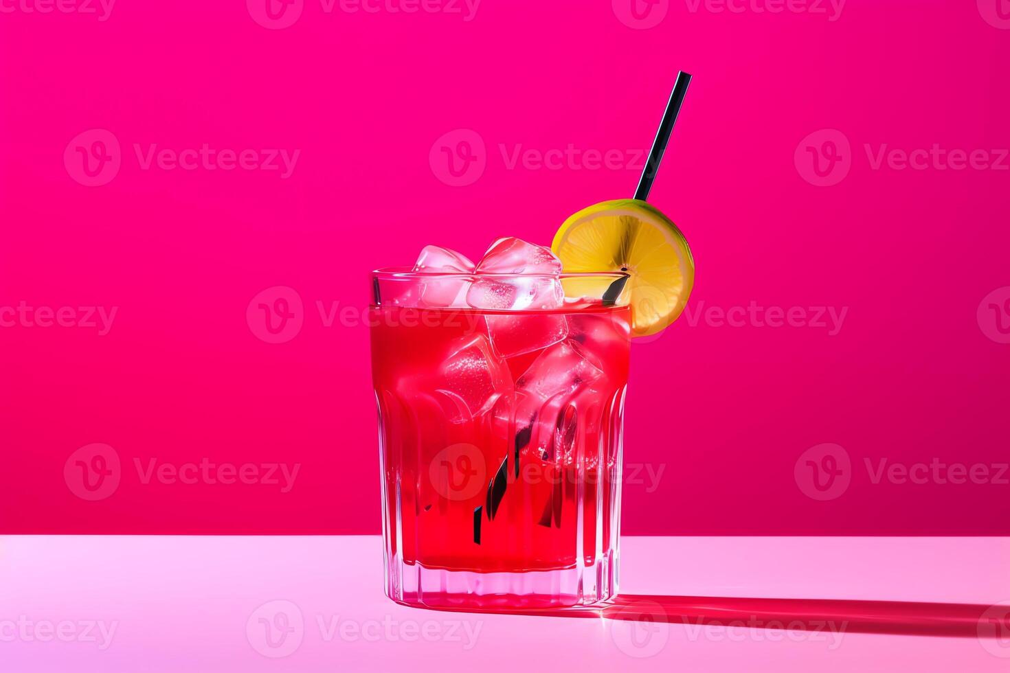 A red drink with ice and lemon on a pink background photo