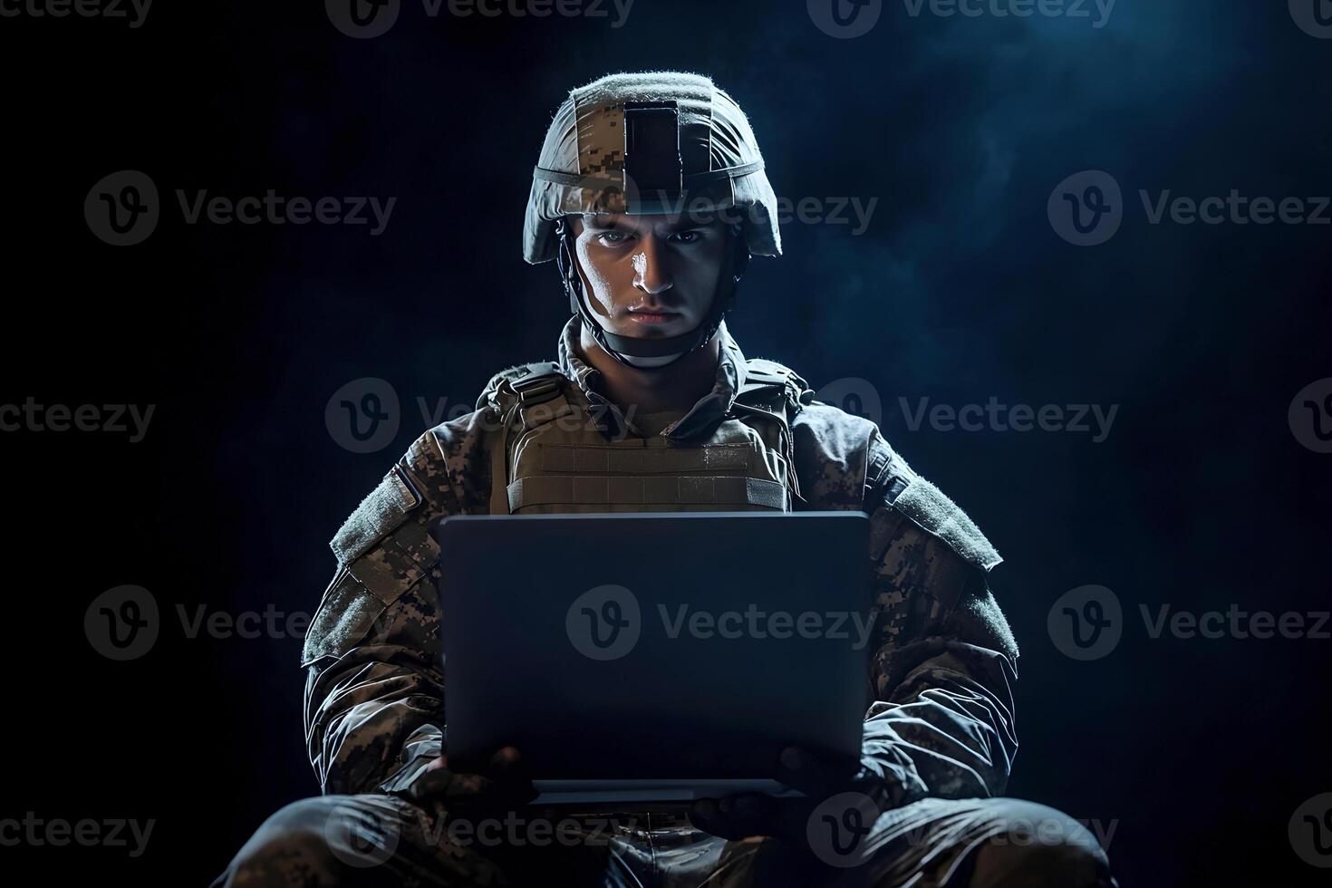 Military personnel engages with technology in a dark setting. photo