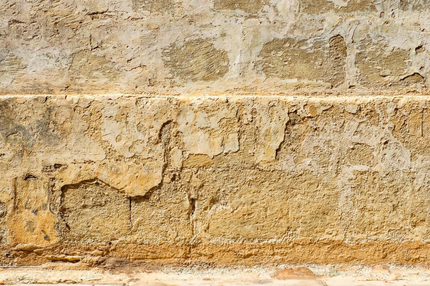 The weathered face of a stone wall in the historic streets of Malta. photo