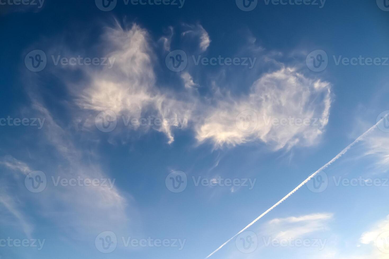 A patchy canvas of bright clouds paints the serene summer sky. photo