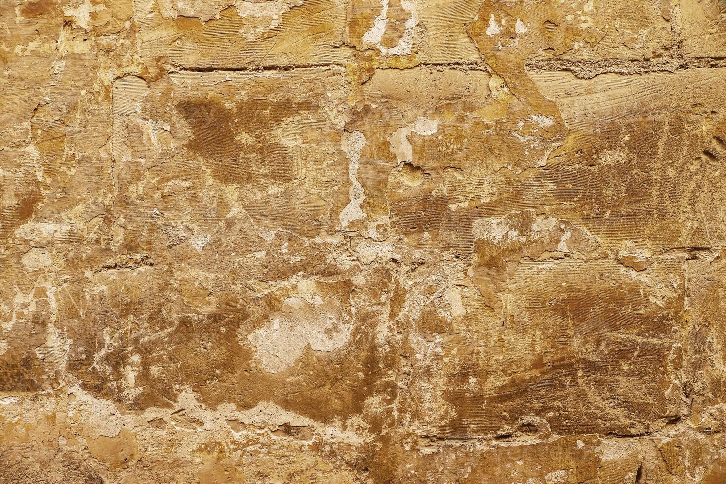 The surface of an old stone wall in the alleyways of Malta's historic towns. photo