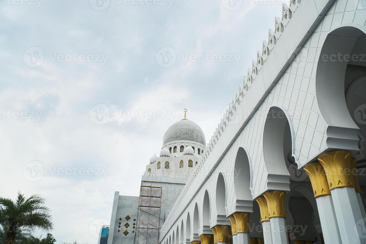 Beautiful Mosque Architecture with Intricate Domes and Arched Details on a Cloudy Day photo