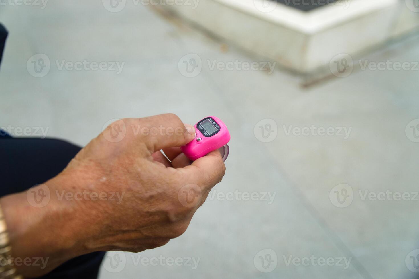 Close-Up of a Hand Holding a Digital Tally Counter photo