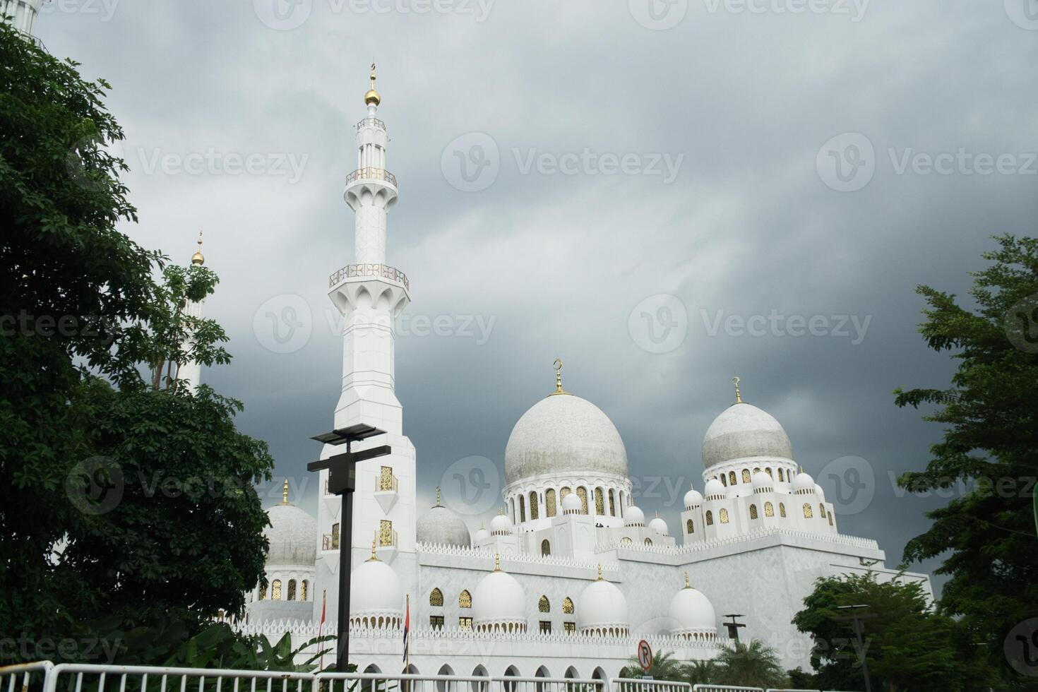 Sheikh Zayed Grand Mosque Landscape with Majestic Cloudy Sky and Surrounding Greenery photo