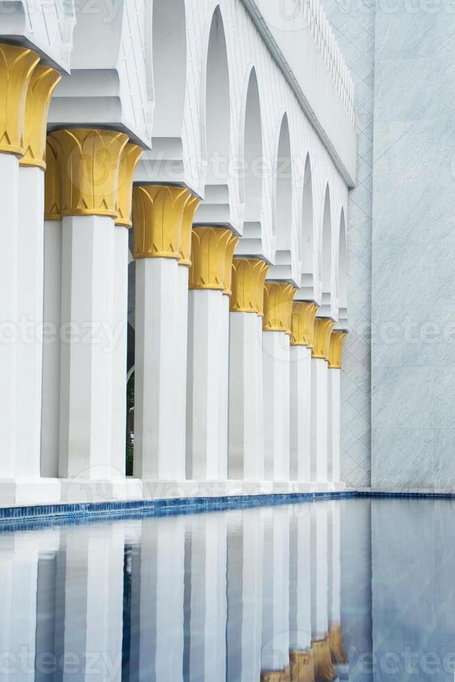Colonnade with Reflective Pool Near Intricate Building photo