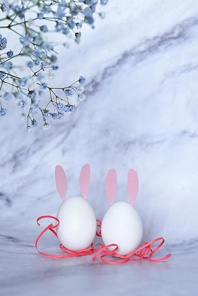 A white card, blank and ready for a message, sits among soft white flowers and speckled quail eggs photo