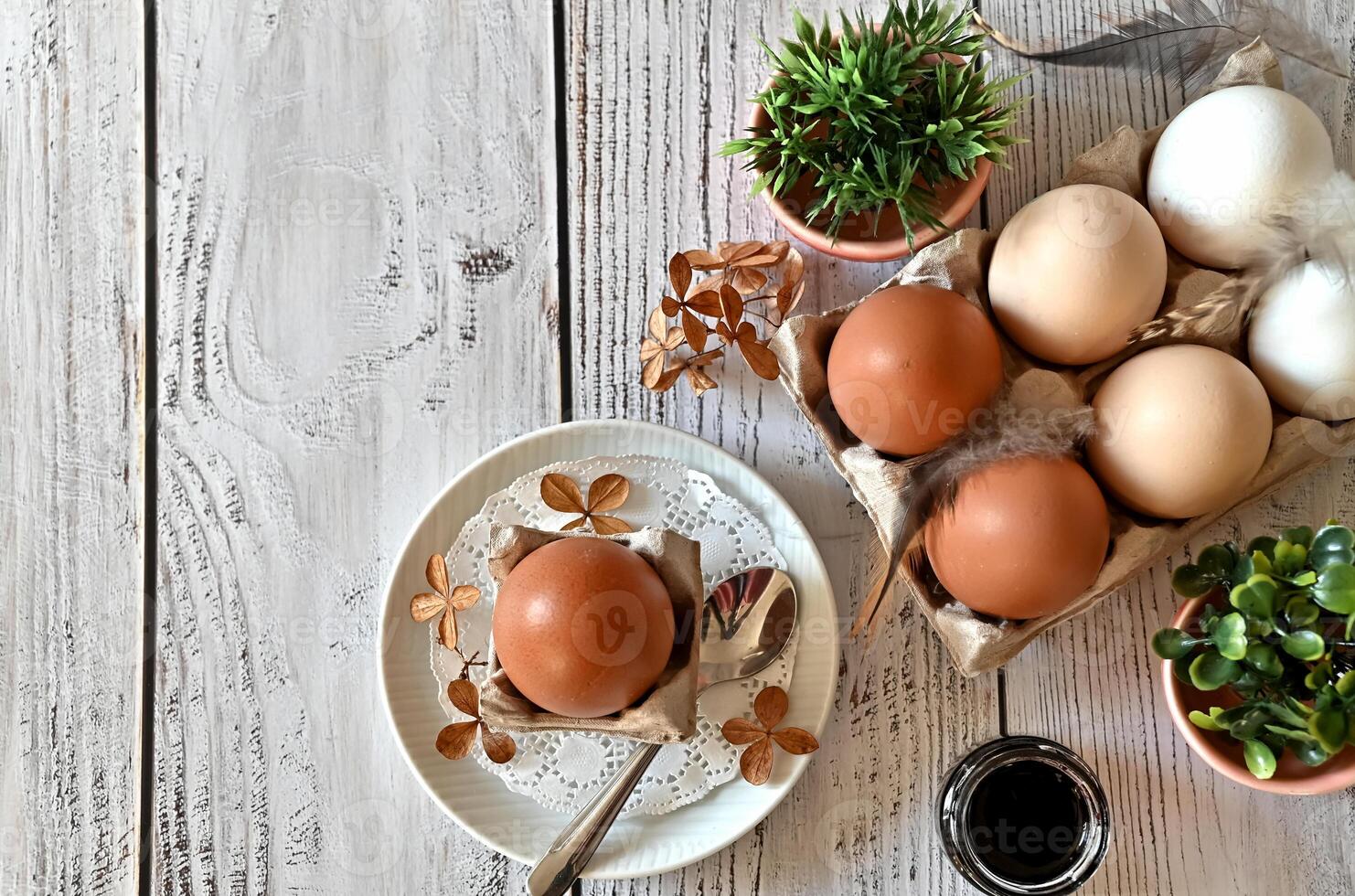 he image is rich in textures, from the smooth surface of the eggs to the delicate petals of the flowers to the crinkled paper in the bowl. photo