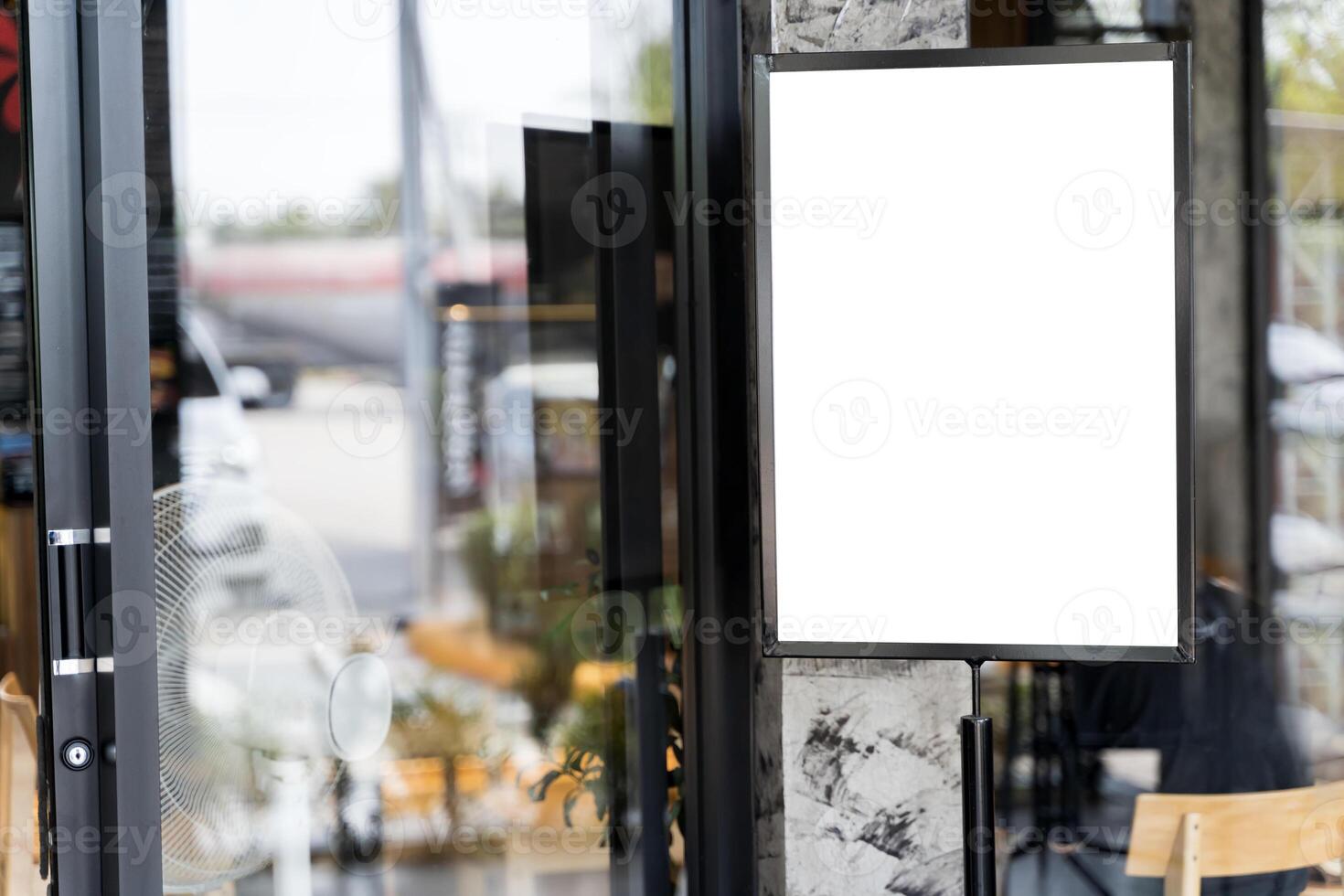 Mockup white poster with black frame stand in front of blur restaurant cafe background for show. photo