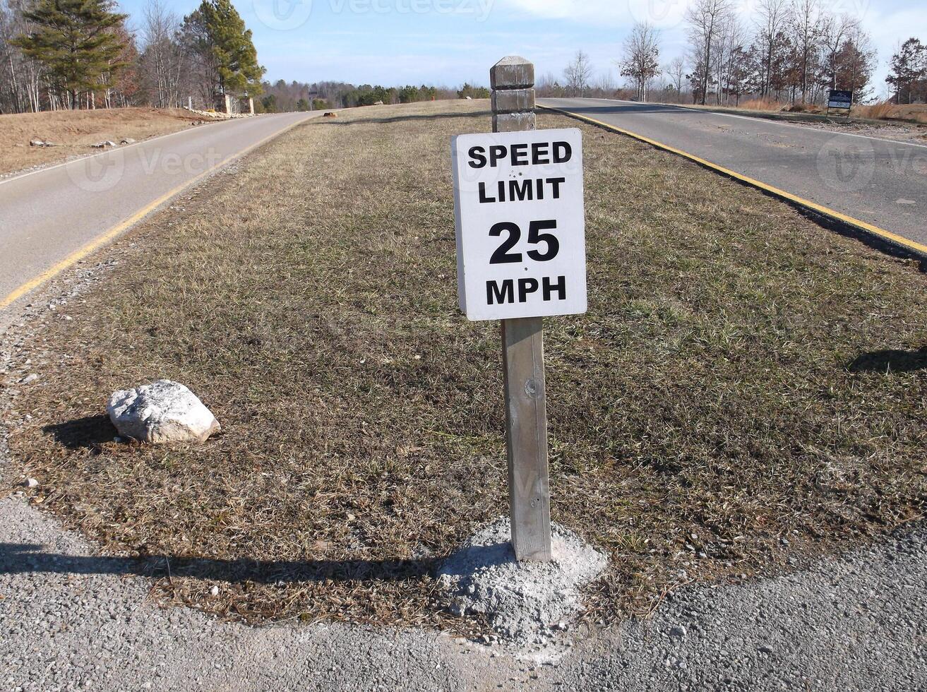 A speed limit sign on a road in the subdivision. photo